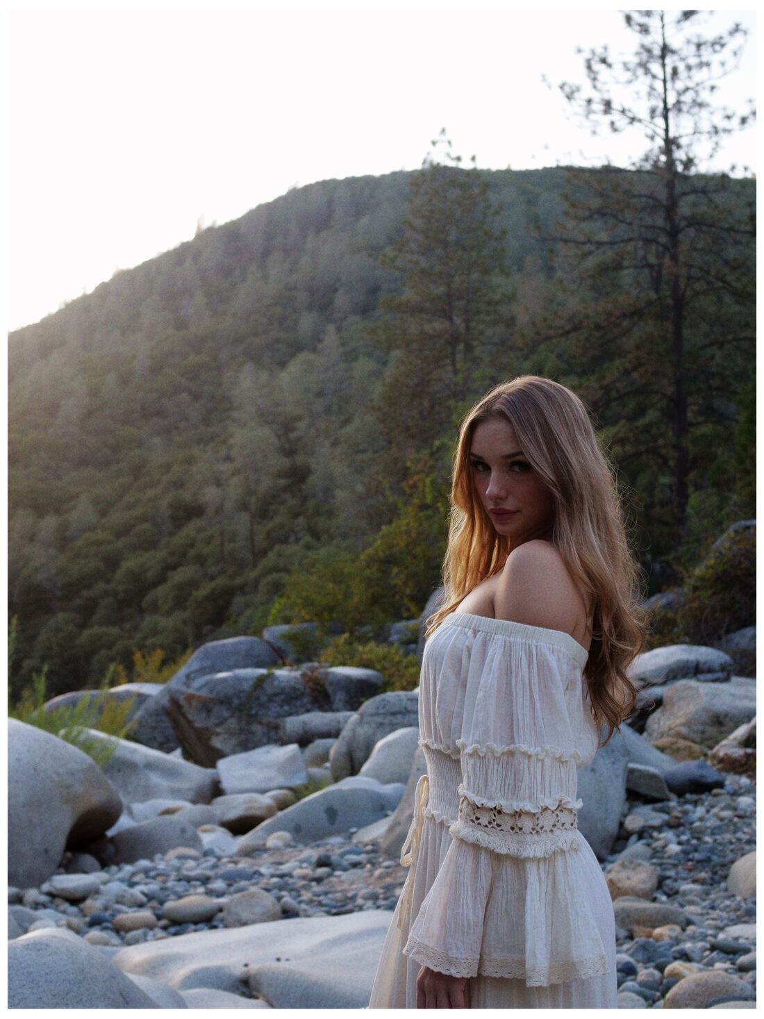 Izzy standing in the riverbed, looking back toward the camera